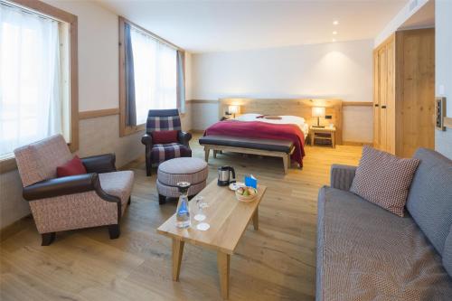 a hotel room with a bed and a living room at Frutt Mountain Resort in Frutt