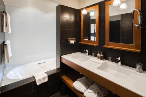 a bathroom with two sinks and a tub at Frutt Mountain Resort in Frutt