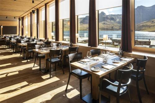 a row of tables and chairs in a room with windows at Frutt Mountain Resort in Frutt