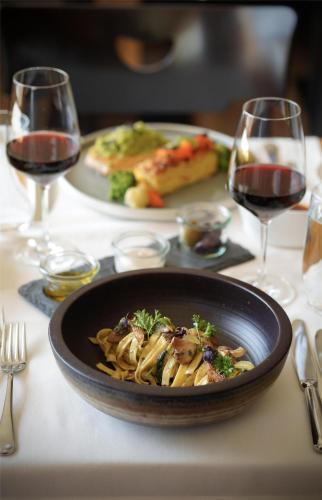 a plate of pasta on a table with glasses of wine at Frutt Mountain Resort in Frutt