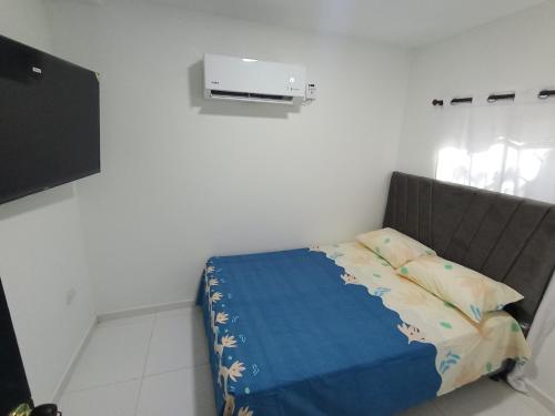 a bedroom with a bed with a blue blanket at Apartamento amoblado in Estación El Salto