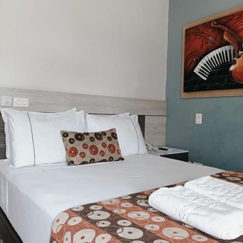 a bedroom with a bed with a white bedspread and pillows at Hotel Santa Clara Boutique in Montería