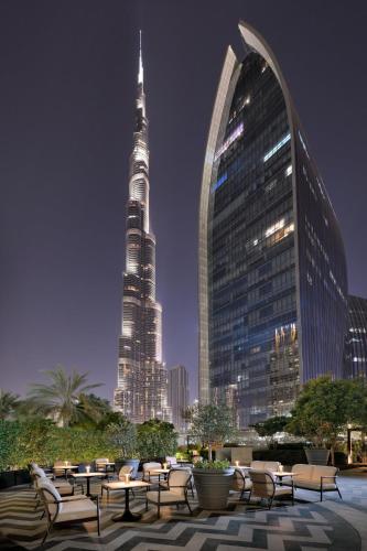 a group of tables and chairs in front of a tall building at Kempinski The Boulevard Dubai in Dubai