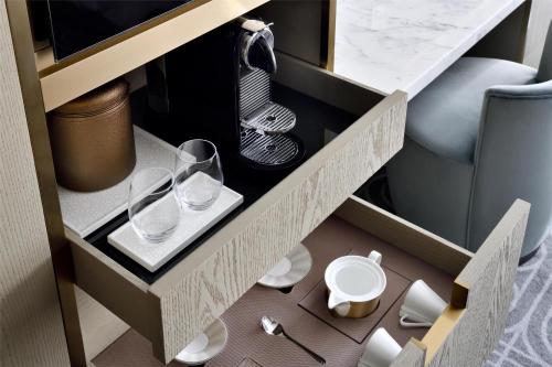 a drawer with two glasses and plates in a cabinet at Kempinski Central Avenue Dubai in Dubai