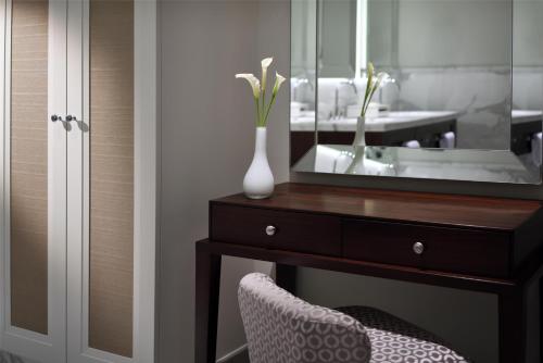 a bathroom with a dresser with a mirror and a sink at Kempinski The Boulevard Dubai in Dubai
