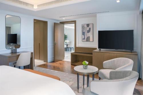a hotel room with a bed and a television at Kempinski Central Avenue Dubai in Dubai