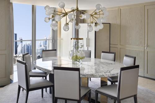 a dining room with a marble table and chairs at Kempinski Central Avenue Dubai in Dubai