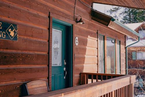 a wooden house with a green door and a porch at The Loose Moose Lodge #6 At Downtown Grand Lake in Grand Lake