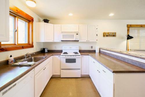 a kitchen with white cabinets and a white stove top oven at The Loose Moose Lodge #6 At Downtown Grand Lake in Grand Lake