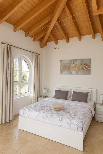 a white bedroom with a large bed in a room at Vila Relaxmountain B&B in São Bartolomeu de Messines
