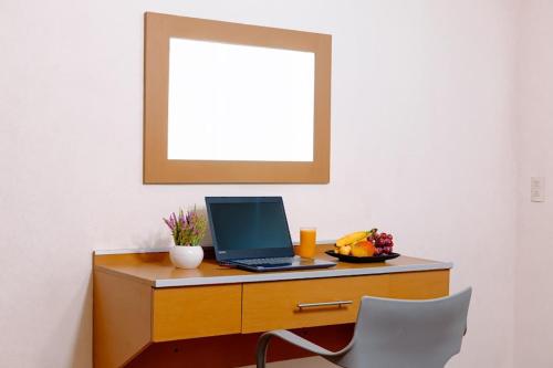 a desk with a laptop computer on top of it at Kasa Hotel & Suites in Irapuato