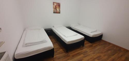 two beds in a room with wooden floors at SandA Apart-1 im EG mit Kostenlose Park in Bul, Bayern in Burglengenfeld