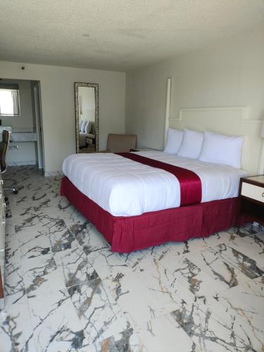 a large bed in a bedroom with a marble floor at Super Inn Motel in Oklahoma City