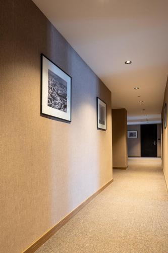 an empty hallway with two pictures on the wall at Downtown Apartments in Pristina