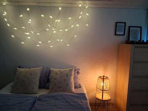 a bedroom with a bed with a string of lights on the wall at Birkenhof Vendégház in Balatonakarattya