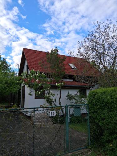 a house with a red roof and a fence at Birkenhof Vendégház in Balatonakarattya