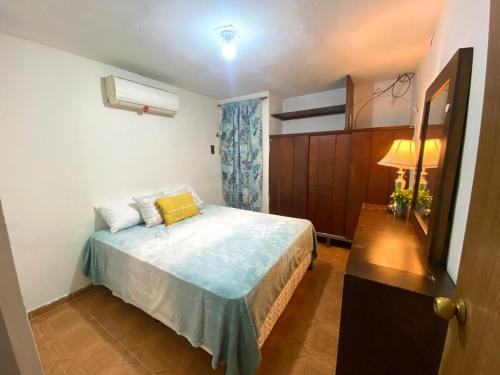 a bedroom with a bed with a yellow pillow on it at Casa Josefa in Champotón