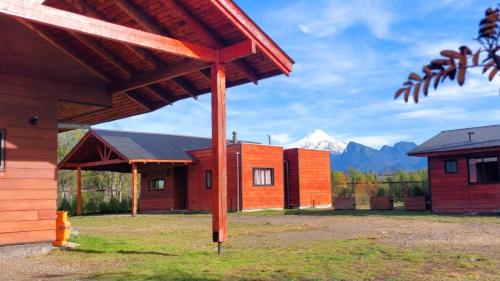 un grupo de edificios con una montaña en el fondo en Cabañas Don Agustín Pucón, en Pucón