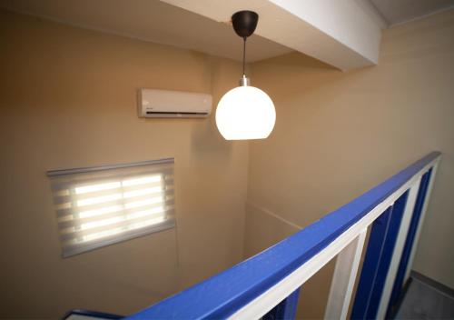 a light hanging from a ceiling in a room with a window at JM GUESTHOUSE Colonial in Santo Domingo
