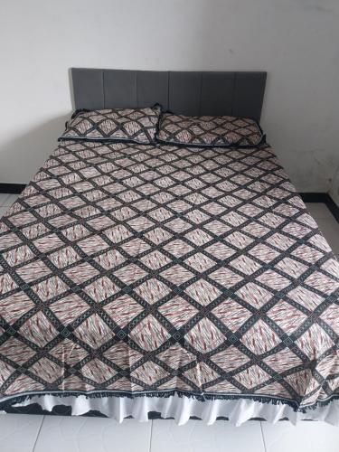 a bed with a comforter on top of it at à 5 minutos do Parque do Povo in Campina Grande