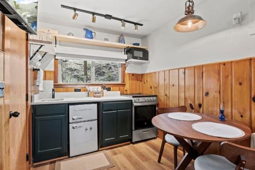 a kitchen with green cabinets and a table and a sink at Timber Lodge #11 in Colorado Springs