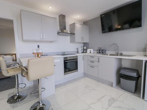 a kitchen with white cabinets and a sink at SJs Annexe in Coleraine
