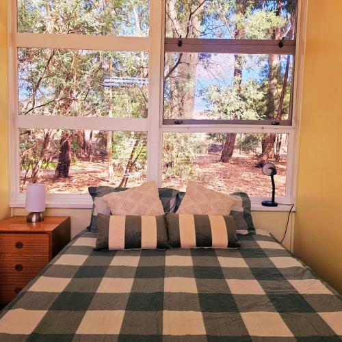 una camera da letto con un letto e una grande finestra di Sunrise Cottage 'Guildford VIC' a Guildford