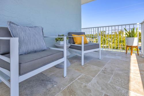 a balcony with two chairs and a yellow pillow at Ocean Shores Villa 1 in Key Largo with pool & boat slip in Key Largo
