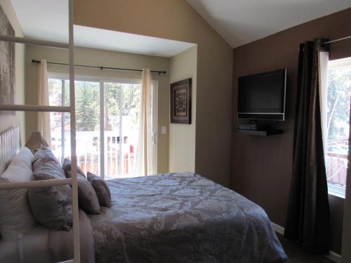 a bedroom with a bed and a tv and a window at Big B's Den in Big Bear Lake