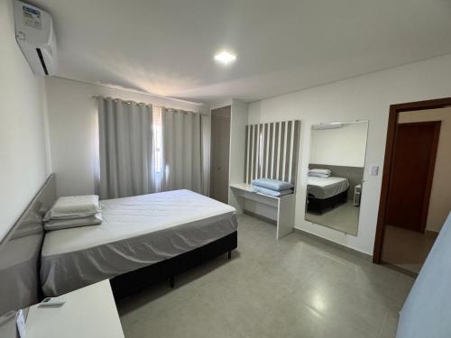 a small bedroom with a bed and a mirror at Casa Top in Porto Seguro