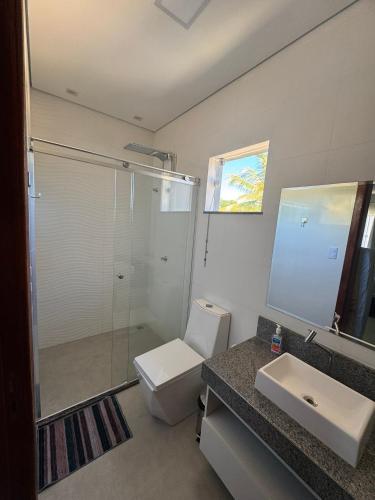 a bathroom with a toilet and a sink and a shower at Casa Top in Porto Seguro