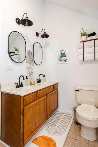 a bathroom with a sink and a toilet and mirrors at Redbird Haven in Berkeley Springs