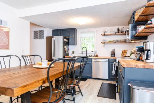 a kitchen with blue cabinets and a wooden table at Redbird Haven in Berkeley Springs