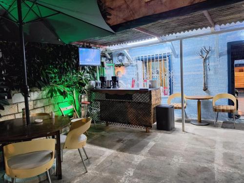a dining room with a table and chairs and an umbrella at War Bunker Hostel in Sarandë