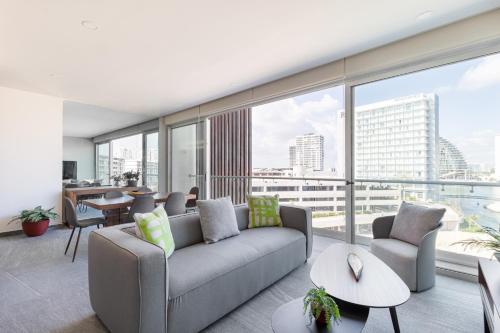 a living room with a couch and a large window at Oceanview 3 BR condo, rooftop pool&jacuzzi, beach! in Cancún