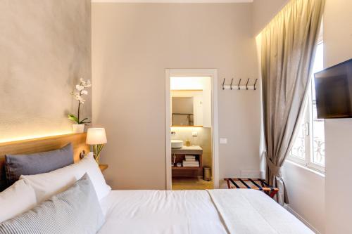 a bedroom with a white bed and a bathroom at The Spanish Suite Campo de' Fiori in Rome