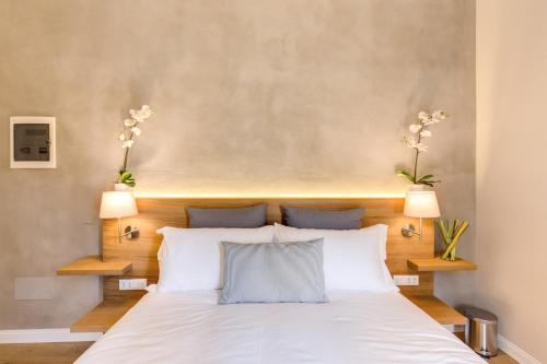 a bedroom with a large white bed with two lamps at The Spanish Suite Campo de' Fiori in Rome