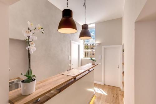 a kitchen with two pendant lights and a wooden counter at The Spanish Suite Campo de' Fiori in Rome