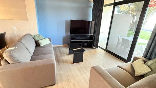Una sala de estar con dos sofás y un televisor de pantalla plana. en Riverview Kalbarri 27 | Family Apt | Pool | Sleeps 7, en Kalbarri