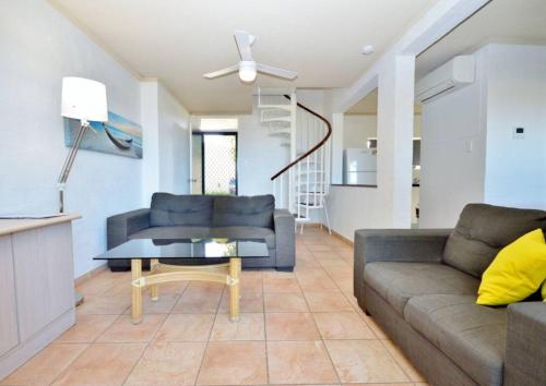 una sala de estar con un sofá y una mesa en Riverview Kalbarri 27 | Family Apt | Pool | Sleeps 7, en Kalbarri