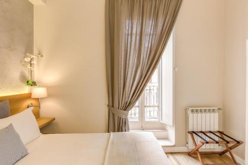 a bedroom with a white bed and a window at The Spanish Suite Campo de' Fiori in Rome
