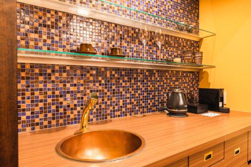 a copper sink in a kitchen with a counter at Tsuta Onsen Ryokan in Towada