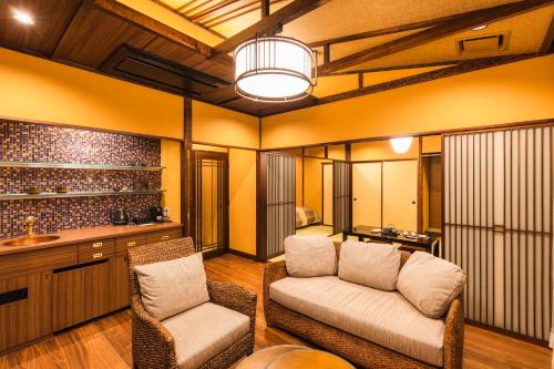 a living room with a couch and a chair at Tsuta Onsen Ryokan in Towada