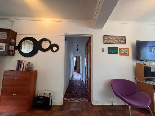 a living room with a purple chair and a hallway at Habitación en Valparaíso privada 1 in Valparaíso
