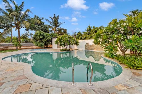 an image of a swimming pool in a backyard with palm trees at Palette - Coastal Grand Hotels & Resorts, OMR in Chennai
