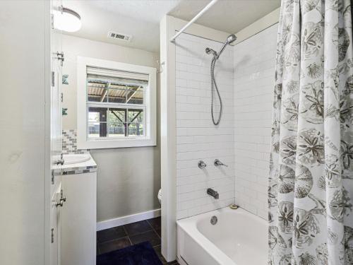 a white bathroom with a tub and a shower at Wahini Wave AP761 in Aransas Pass