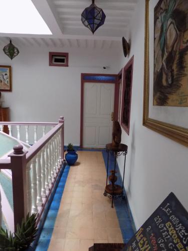 a hallway with a white door and a tile floor at Hôtel Riad Gnaoua in Essaouira