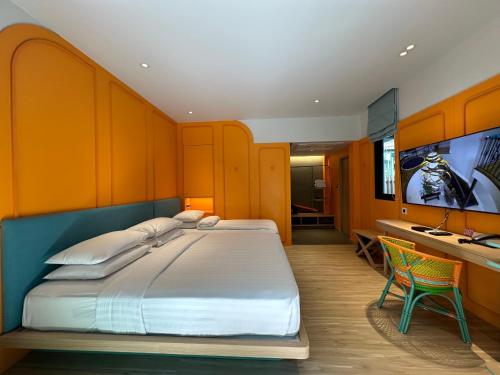 a bedroom with a large bed and a desk at Banlansuan Resort SHA Plus in Cha Am