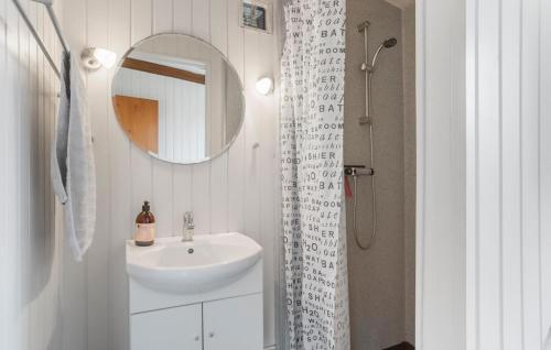a white bathroom with a sink and a mirror at Lærkereden in Allinge