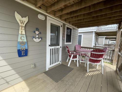 a porch of a house with a table and chairs at NC 12 56821-18 Condo in Hatteras